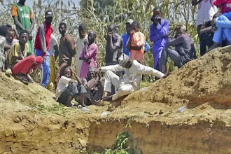 Dozens of people gathered around a mass grave where some of the people who lost their lives in the explosion were buried.