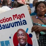 An NPP party supporter with a Bawumia placard with the inscription "Action Man Bawumia".