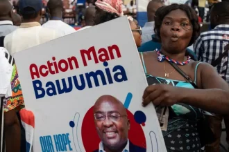 An NPP party supporter with a Bawumia placard with the inscription "Action Man Bawumia".