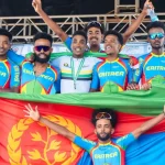 The Eritrean cycling team posing with their nation's flag in a group photo.