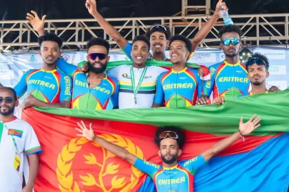 The Eritrean cycling team posing with their nation's flag in a group photo.