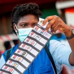 A Ghanaian Electoral Commission official inspecting the 2020 presidential election ballot paper