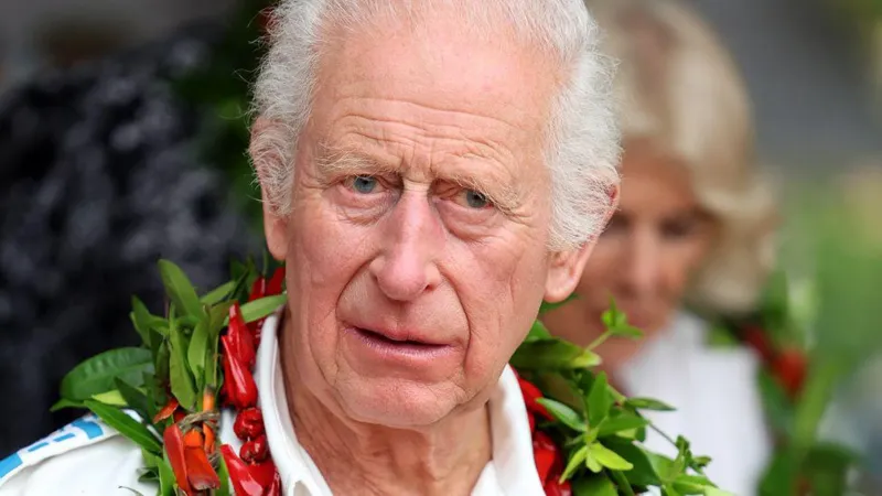 King Charles III in a white shirt and a garland of dried fruits from the pandanus tree put around his neck on his visit to Samoa.