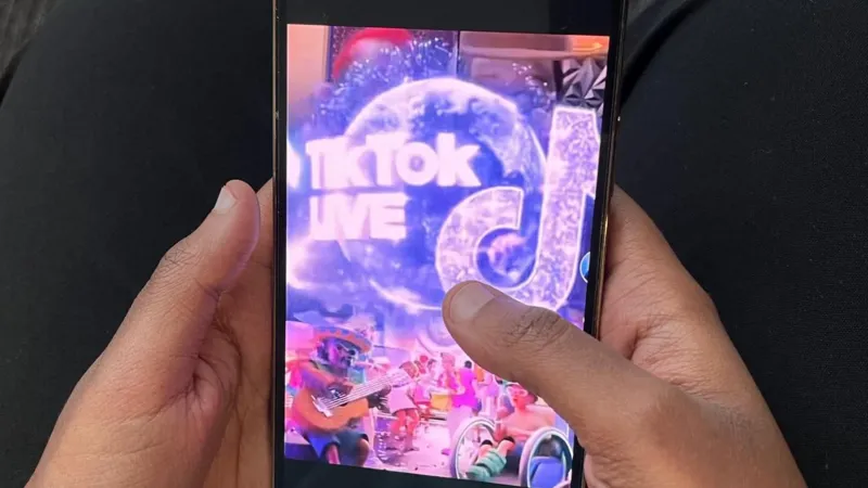 A mobile phone's screen displaying TikTok live and the app's logo.