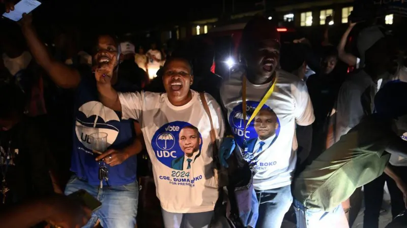 A group of UDC supporters in their party paraphernalia celebrating in the nght.